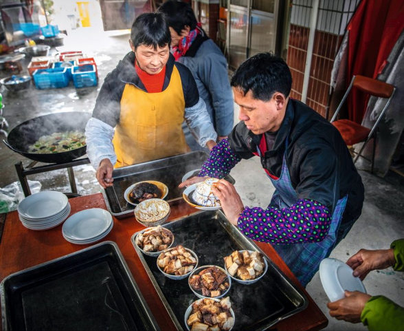 近景：村民在厨房里准备饭菜的生活现场